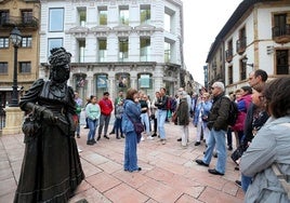 Un grupo de turistas junto a la estatua de La Regenta, en Oviedo.